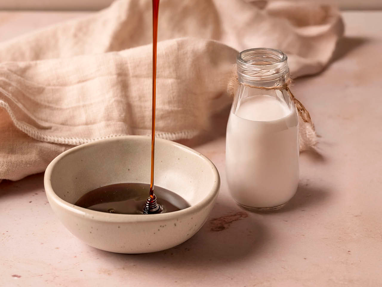 Eine Flasche Milch und eine Schuessel voller Karamell
