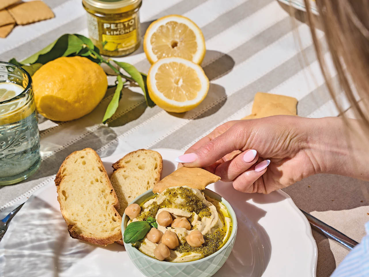 Frau die hummus mit zitronen pesto isst